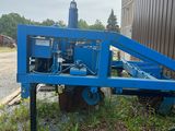 un tracteur bleu garé à côté d'un bâtiment