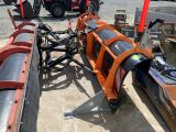a snow plow sitting on the ground next to a tractor