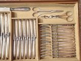 many different types of knives and spoons in a box