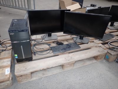 deux écrans d'ordinateur et un clavier posés sur une palette