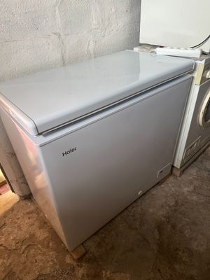 un petit réfrigérateur blanc à côté d'un sèche-linge et d'un sèche-linge