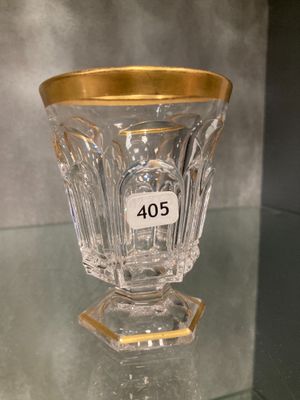 a glass vase with a gold rim sitting on a glass shelf