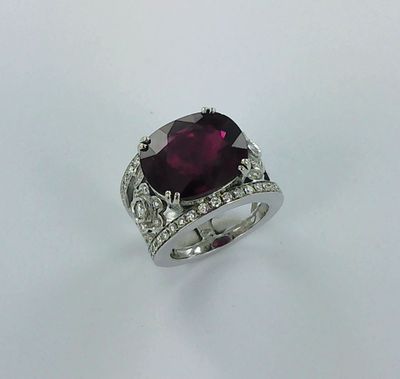 une bague ornée d'un gros rubis taille coussin entouré de diamants