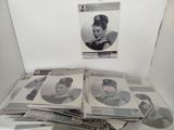 a lot of records on a table with a picture of a woman on it