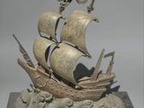 statue of a ship on a wave with a flag on it