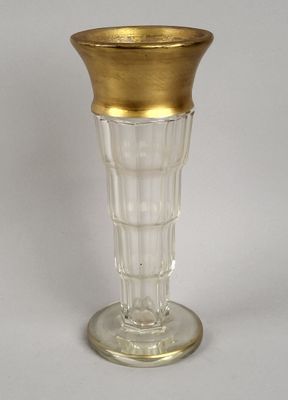 un vase en verre à bord doré posé sur une table