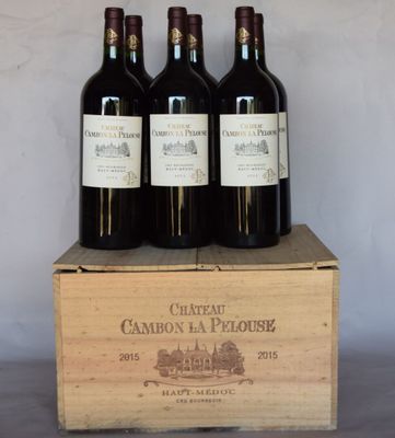 trois bouteilles de vin rouge dans un coffret en bois sur une table