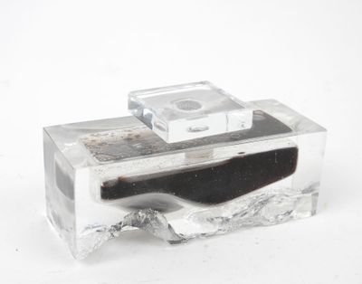 une boîte en verre contenant un objet noir
