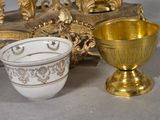 a gold cup and a white bowl sitting next to each other