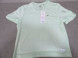 a close up of a shirt on a bed with a tag on it