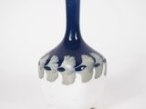 un vase bleu et blanc posé sur une surface blanche