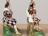 two figurines of a man and a woman sitting on a rock