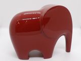 une figurine d'éléphant rouge posée sur une surface blanche