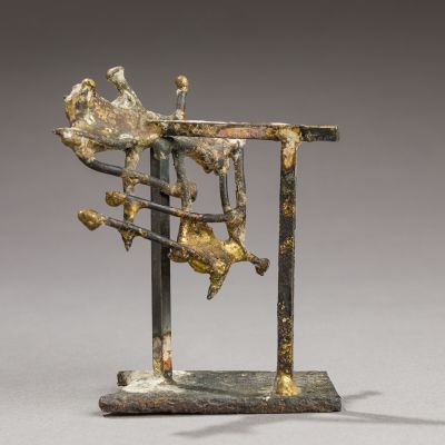 une sculpture en bronze représentant un homme assis sur une table