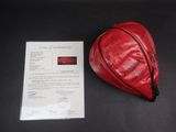 a red bag that is sitting next to a piece of paper