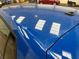 a blue car parked in a parking lot next to other cars
