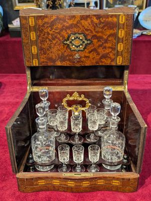 a wooden box with glasses in it on a red carpet