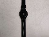 the watch is laying on a white surface with a black strap