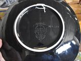 a person holding a black plate with a black design on it