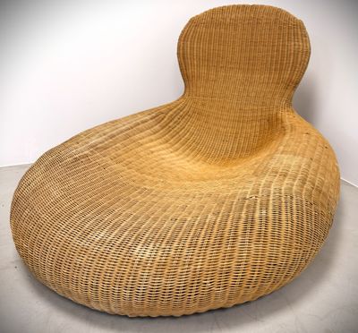 an image of a wicker chair in a room with a white wall