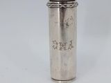 an old silver cup with a straw in it sitting on a white surface
