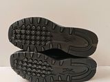pair of black shoes on a white surface with a white background
