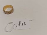 une bague et une étiquette sur une surface blanche