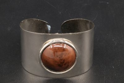 bracelet manchette en argent orné d'une pierre rouge au centre