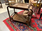 une petite table avec une étagère en bois posée sur un tapis