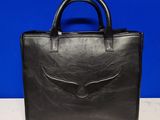 a black leather handbag with an eagle emblem on the front