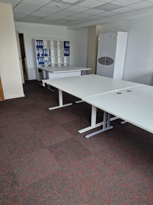une pièce équipée de deux tables et d'un réfrigérateur