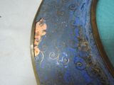 a close up of a blue vase with a gold decoration