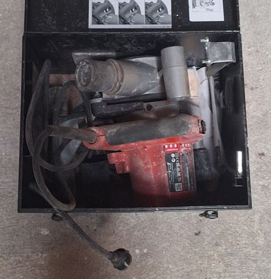 a box with a drill and other tools inside of it