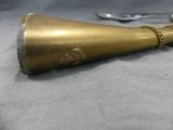 a gold bell on a table with a pair of scissors