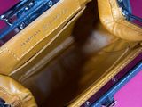 a hand holding a purse that is open on a pink surface