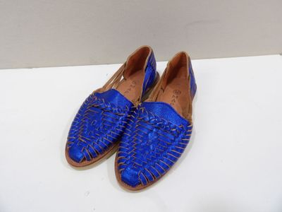 pair of blue woven shoes on a white surface