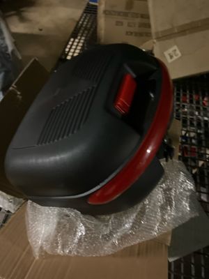 un sèche-cheveux noir et rouge posé sur une boîte en carton