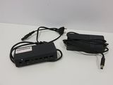 a black power strip and a charger on a white table