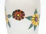 a white vase with yellow and blue flowers painted on it