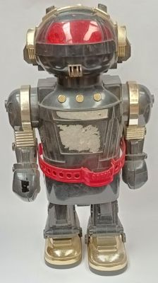 a toy robot that is standing on a white surface