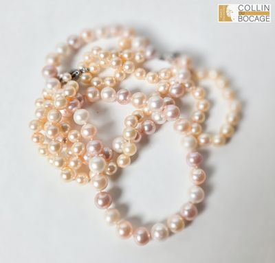 trois rangs de perles sont disposés sur une surface blanche
