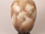 a vase that has a flower on it on a stand