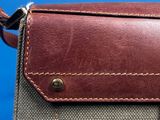 a brown and grey bag on a blue surface