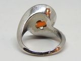 une bague en argent avec un poisson orange à l'intérieur