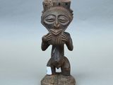 une vieille figurine en bois représentant un homme avec un chapeau sur la tête