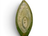 a green object with a face on it on a white surface