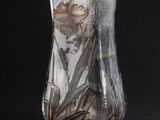 un vase en verre contenant une fleur, sur fond noir