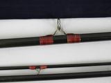 two black and red fishing rods sitting on top of a white surface