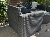 a black wicker couch sitting on a patio