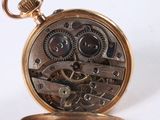 a close up of a pocket watch on a white surface